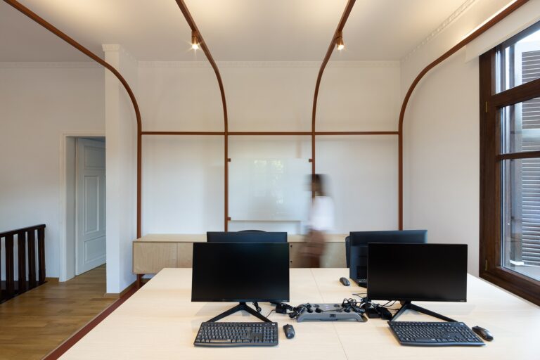 Clean lines, colored wall partitions and a monochromatic floor adorn working place interior in Thessaloniki, Greece